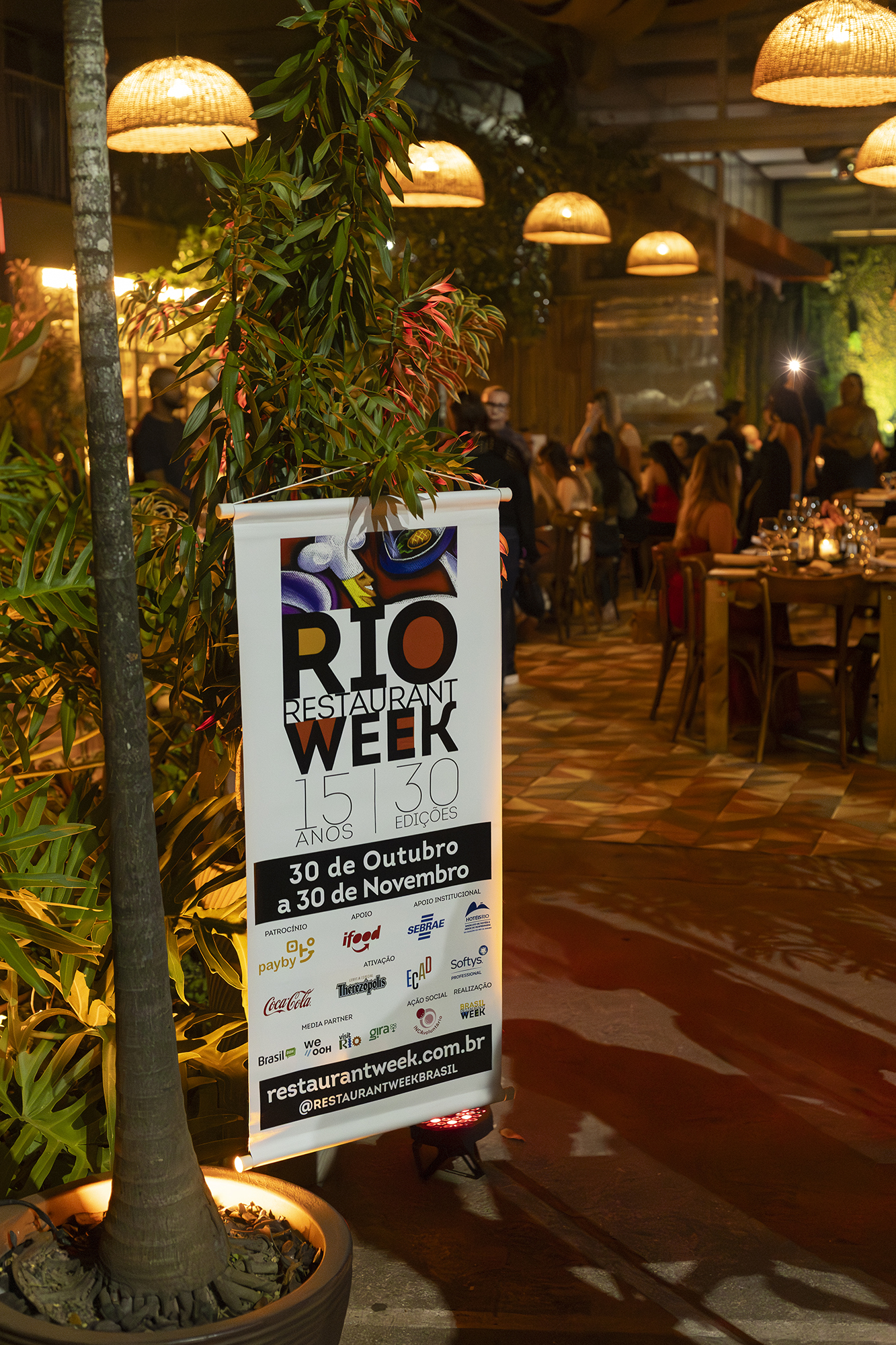 Banner do Rio Restaurant Week 15 anos 30 edições em restaurante elegante com iluminação ambiente e clientes jantando